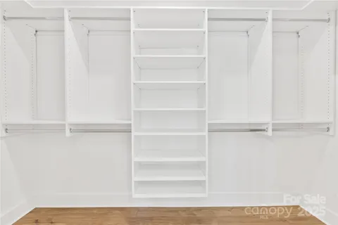 a view of walk in closet with empty racks