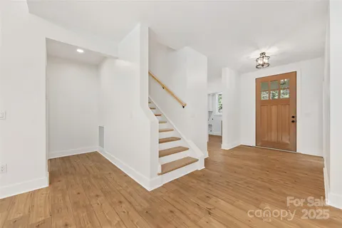 a view of a hallway with wooden floor and staircase