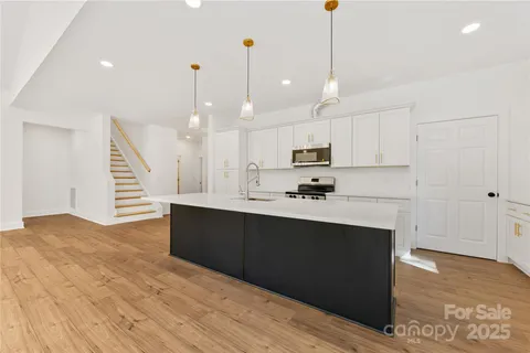a kitchen with kitchen island a sink stainless steel appliances and cabinets