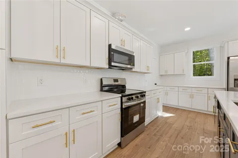 a kitchen with white cabinets stainless steel appliances and sink