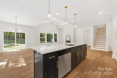 a kitchen with a sink a window and wooden floor