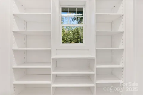 a view of walk in closet with empty racks