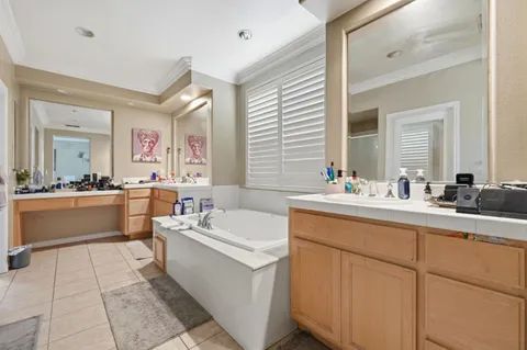 a bathroom with a double vanity sink a mirror and a bathtub