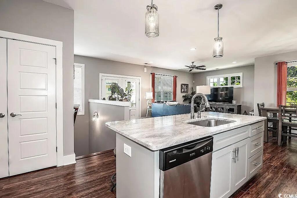 399 Lumbee Circle Pawleys Island, SC 29585 - Photo 12 of 30 Kitchen featuring dishwasher, dark wood-style flooring, hanging light fixtures, a kitchen island with sink, and white cabinets