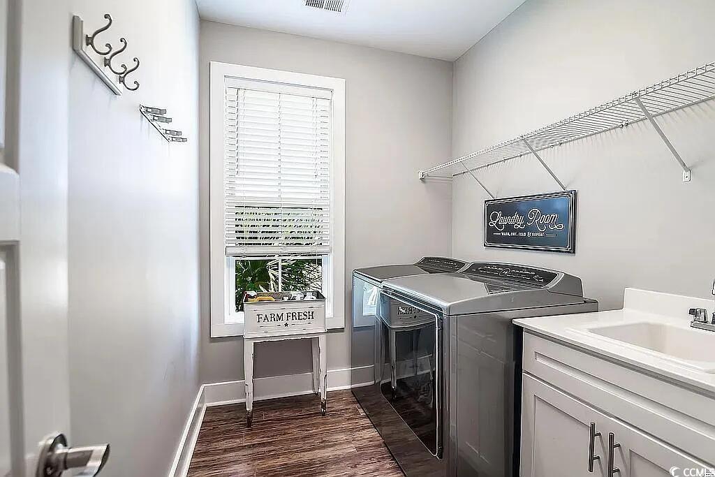 399 Lumbee Circle Pawleys Island, SC 29585 - Photo 14 of 30 Laundry room featuring washer and clothes dryer, dark wood-style flooring, and cabinet space