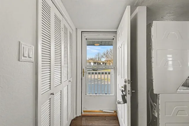 a view of a hallway with wooden floor and closet