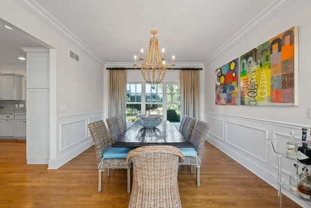 a view of a dining room with furniture a chandelier and wooden floor