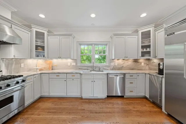 a kitchen with granite countertop a refrigerator and wooden cabinets
