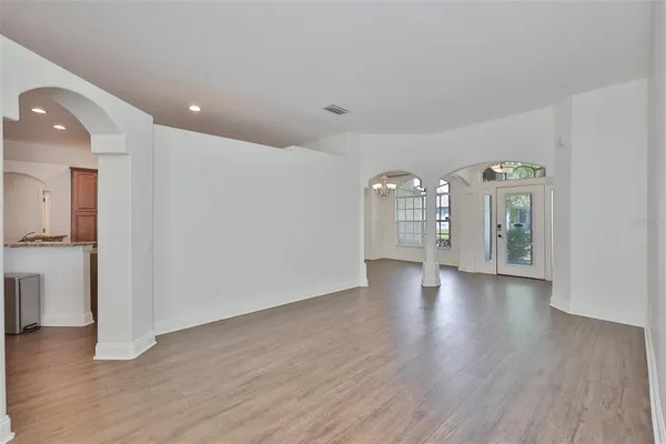 a view of a big room with wooden floor and a kitchen