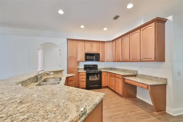 a kitchen with granite countertop stainless steel appliances and wooden cabinets