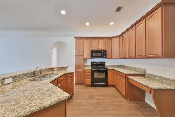 a kitchen with stainless steel appliances granite countertop a sink stove and refrigerator