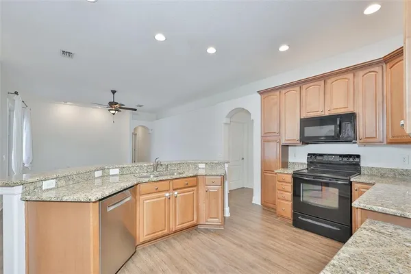 a kitchen with stainless steel appliances granite countertop a sink stove and refrigerator