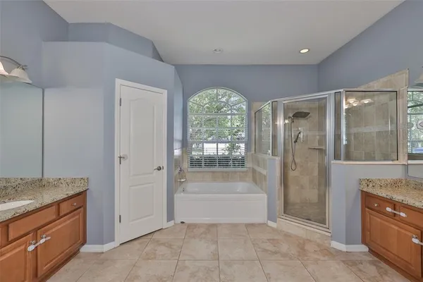 a spacious bathroom with a granite countertop tub shower and sink