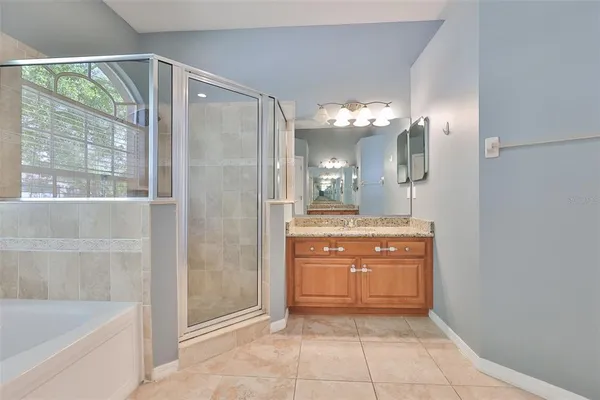 a bathroom with a granite countertop sink a mirror and a bathtub