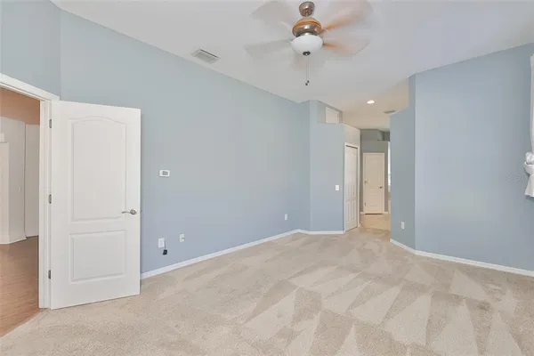 an empty room with a ceiling fan and a window