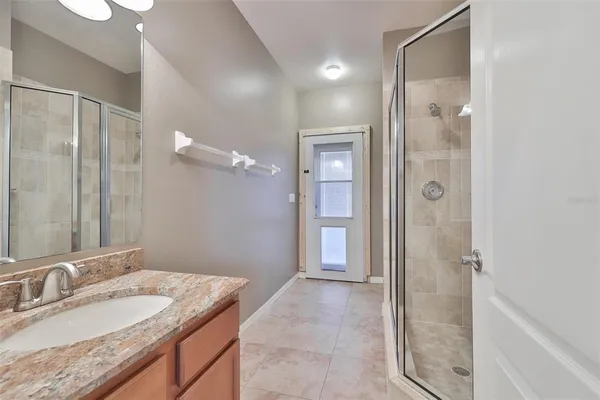 a bathroom with a granite countertop sink mirror and shower