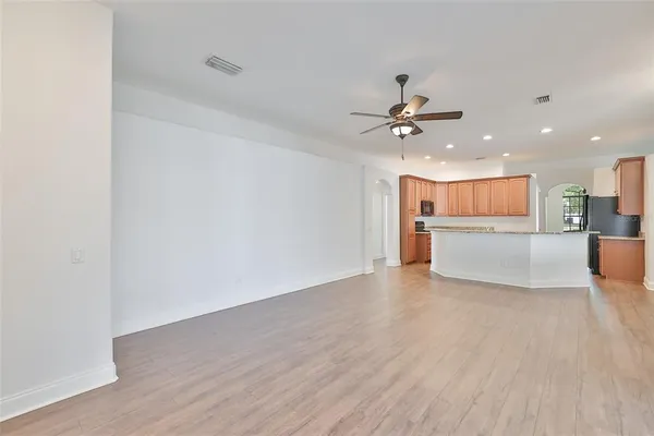 a view of a livingroom with a kitchen counter tops and a ceiling fan