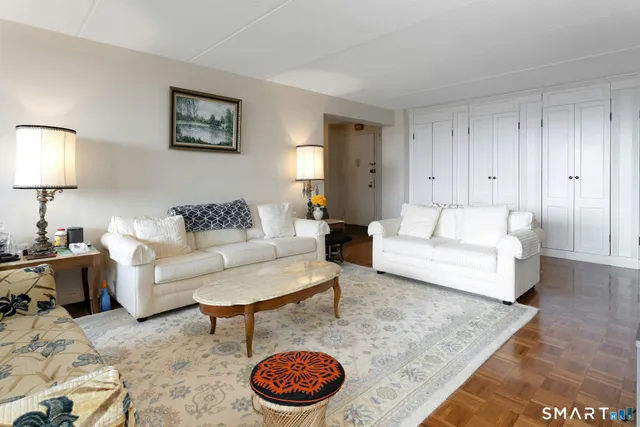 a living room with furniture a rug and a lamp