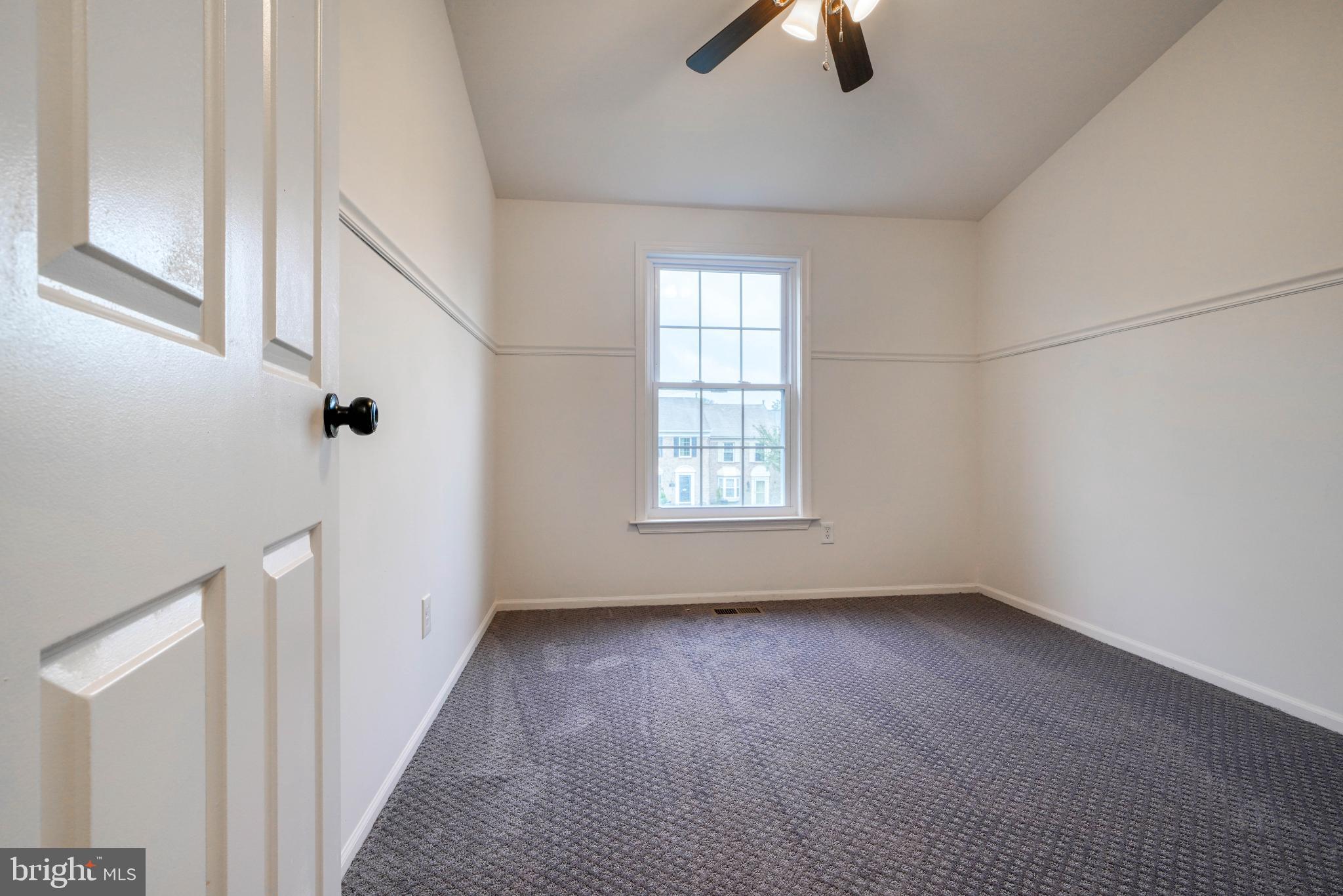 7233 Brookfalls Terrace Baltimore, MD 21209 - Photo 11 of 26 an empty room with chandelier fan and windows