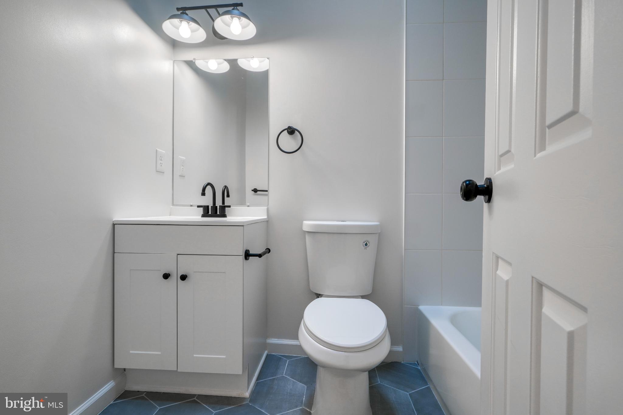 7233 Brookfalls Terrace Baltimore, MD 21209 - Photo 12 of 26 a bathroom with a sink a toilet a mirror and shower