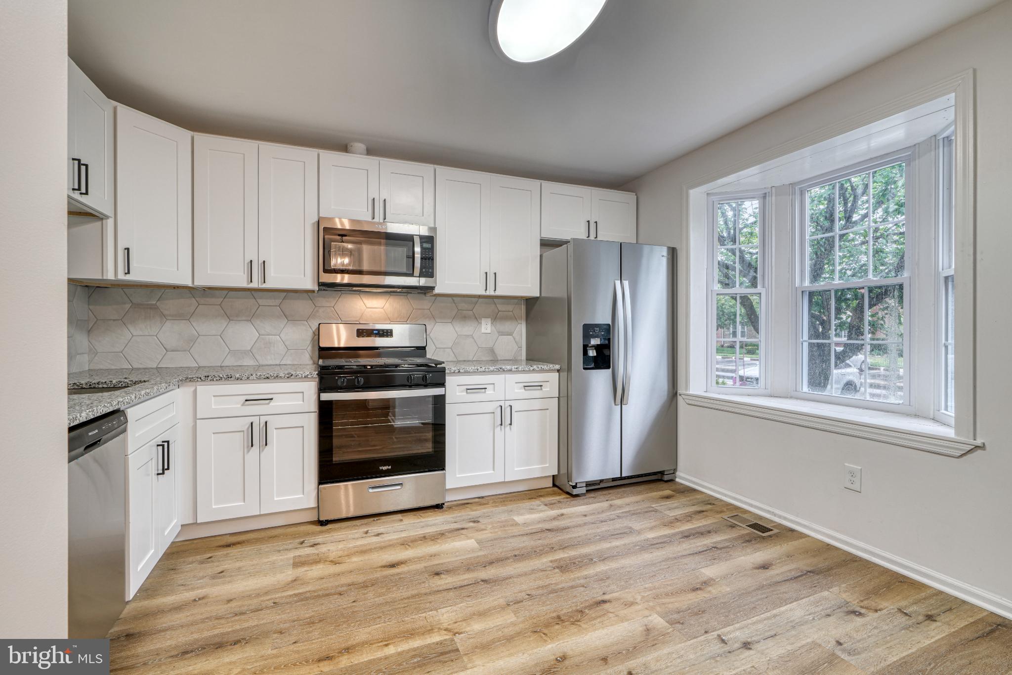 7233 Brookfalls Terrace Baltimore, MD 21209 - Photo 4 of 26 a kitchen with white cabinets and stainless steel appliances