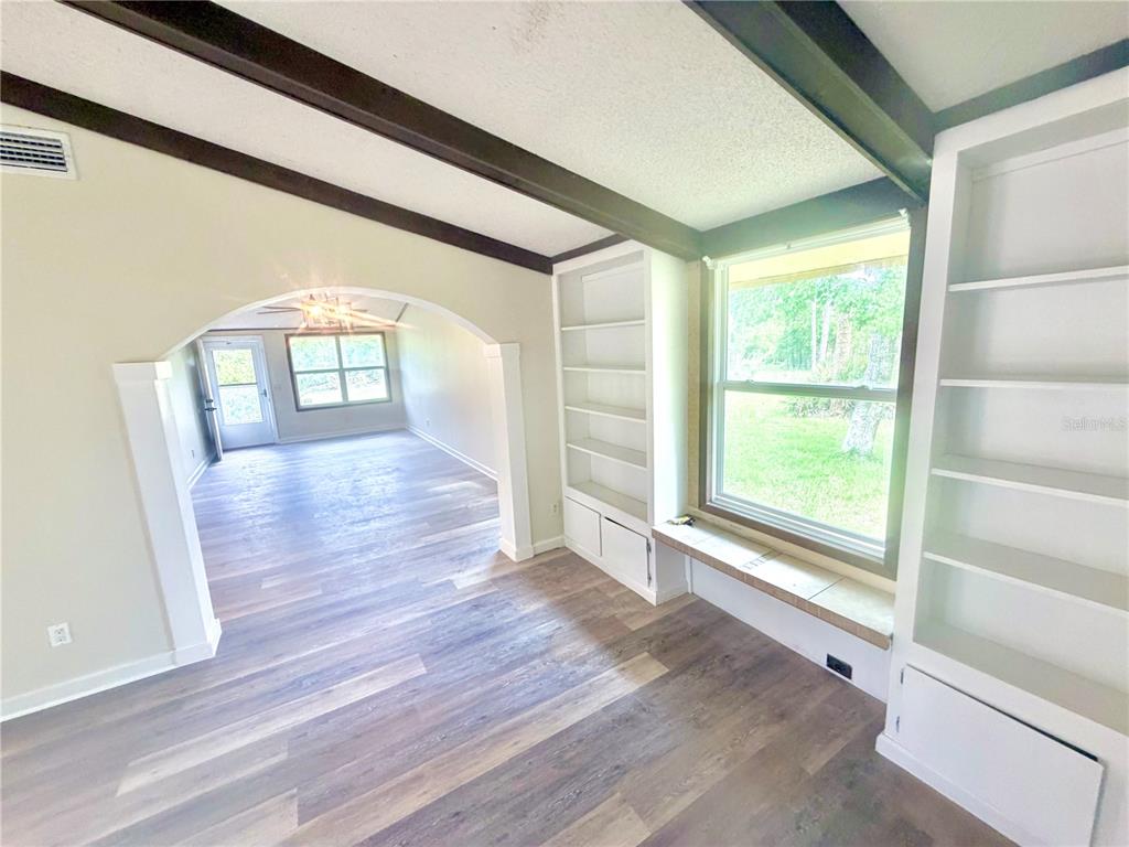 375 Pine Woods Road Ormond Beach, FL 32174 - Photo 5 of 16 an empty room with wooden floor and windows