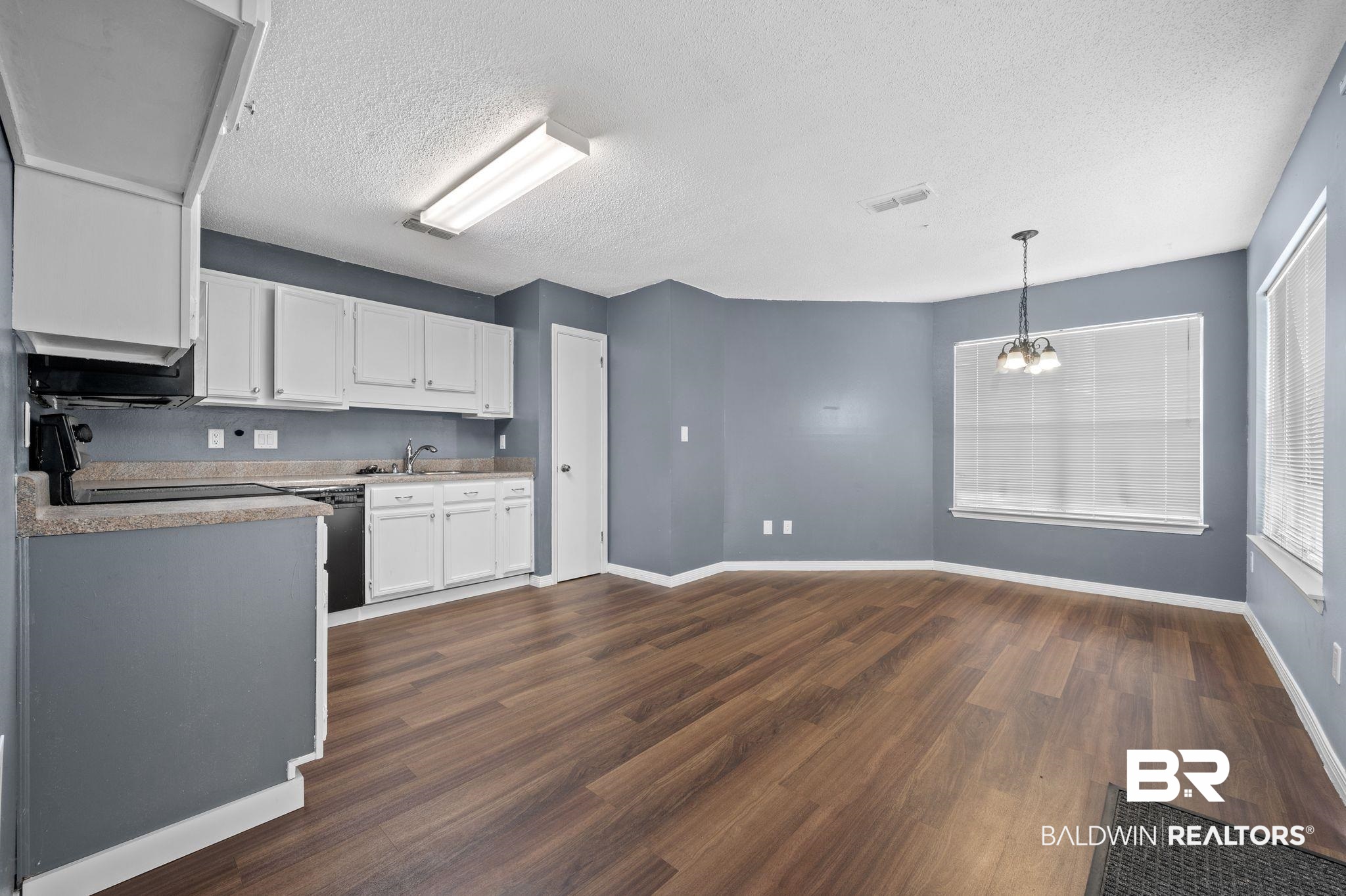 3716 Pepper Ridge Drive Mobile, AL 36693 - Photo 8 of 20 Kitchen featuring dark wood-type flooring, hanging light fixtures, an inviting chandelier, white cabinets, and black dishwasher