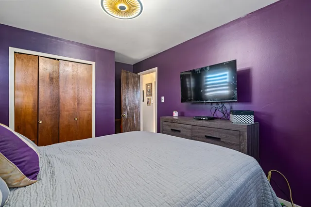 a bedroom with a bed and a flat screen tv