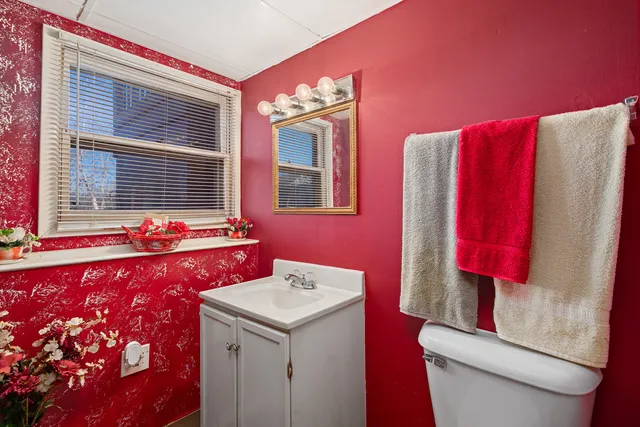 a bathroom with a bathtub sink vanity mirror and toilet