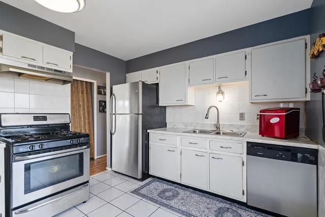 a kitchen with stainless steel appliances a stove a sink and a refrigerator