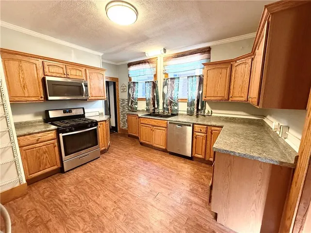 a kitchen with stainless steel appliances granite countertop a stove a sink and a refrigerator