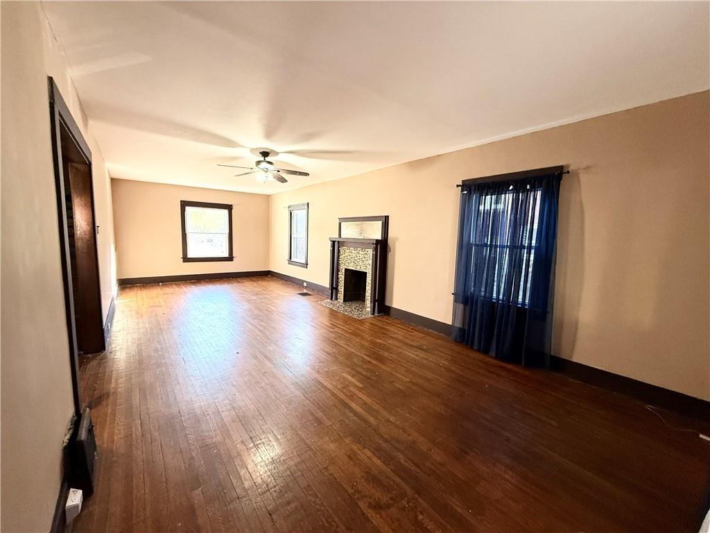 92 Euclid Avenue Sharon, PA 16146 - Photo 5 of 17 an empty room with wooden floor fireplace and windows