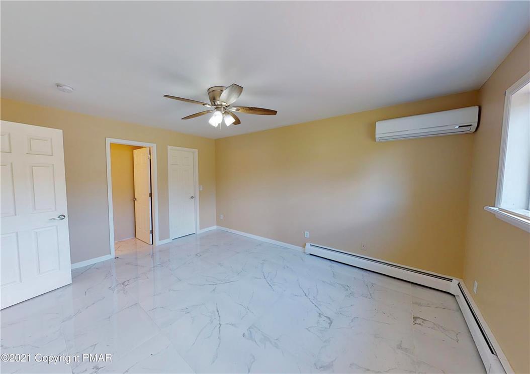 1110 Misty Ridge East Stroudsburg, PA 18302 - Photo 36 of 43 A well-lit bedroom features cool flooring and a ceiling fan for comfort.