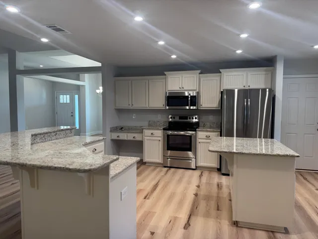 a kitchen with kitchen island a sink stainless steel appliances and cabinets