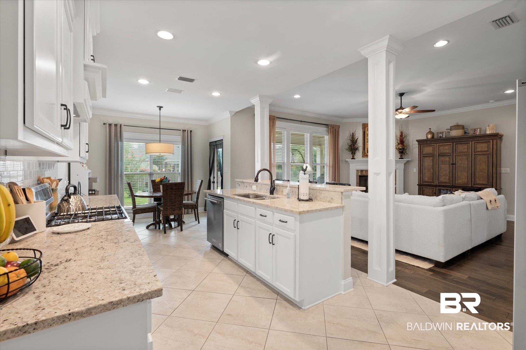 24821 Austin Road Daphne, AL 36526 - Photo 24 of 24 Kitchen with decorative columns, crown molding, open floor plan, plenty of natural light, and light tile patterned floors