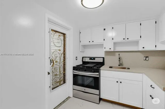 a kitchen with cabinets appliances and a wooden floor