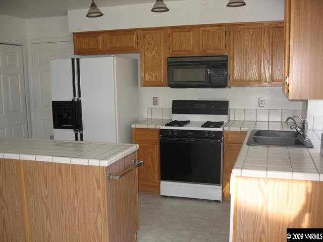 1275 High Chaparral Drive Reno, NV 89521 - Photo 2 of 9 a kitchen with granite countertop a sink stove and microwave
