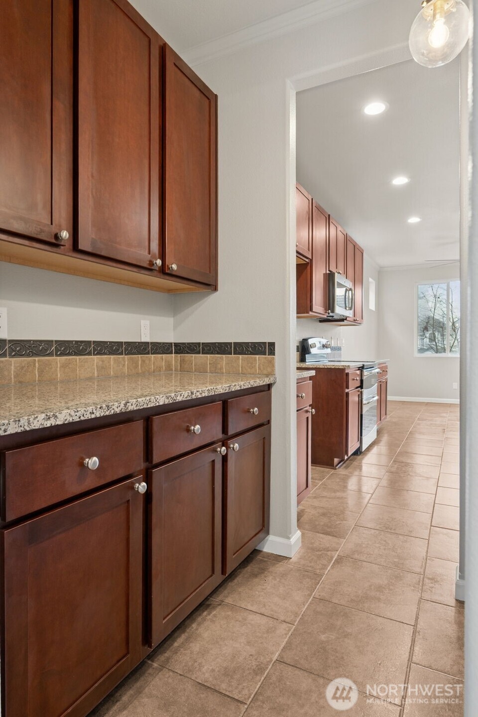 9248 Periwinkle Loop Northeast Olympia, WA 98516 - Photo 11 of 39 a kitchen with stainless steel appliances granite countertop a stove a sink and a microwave