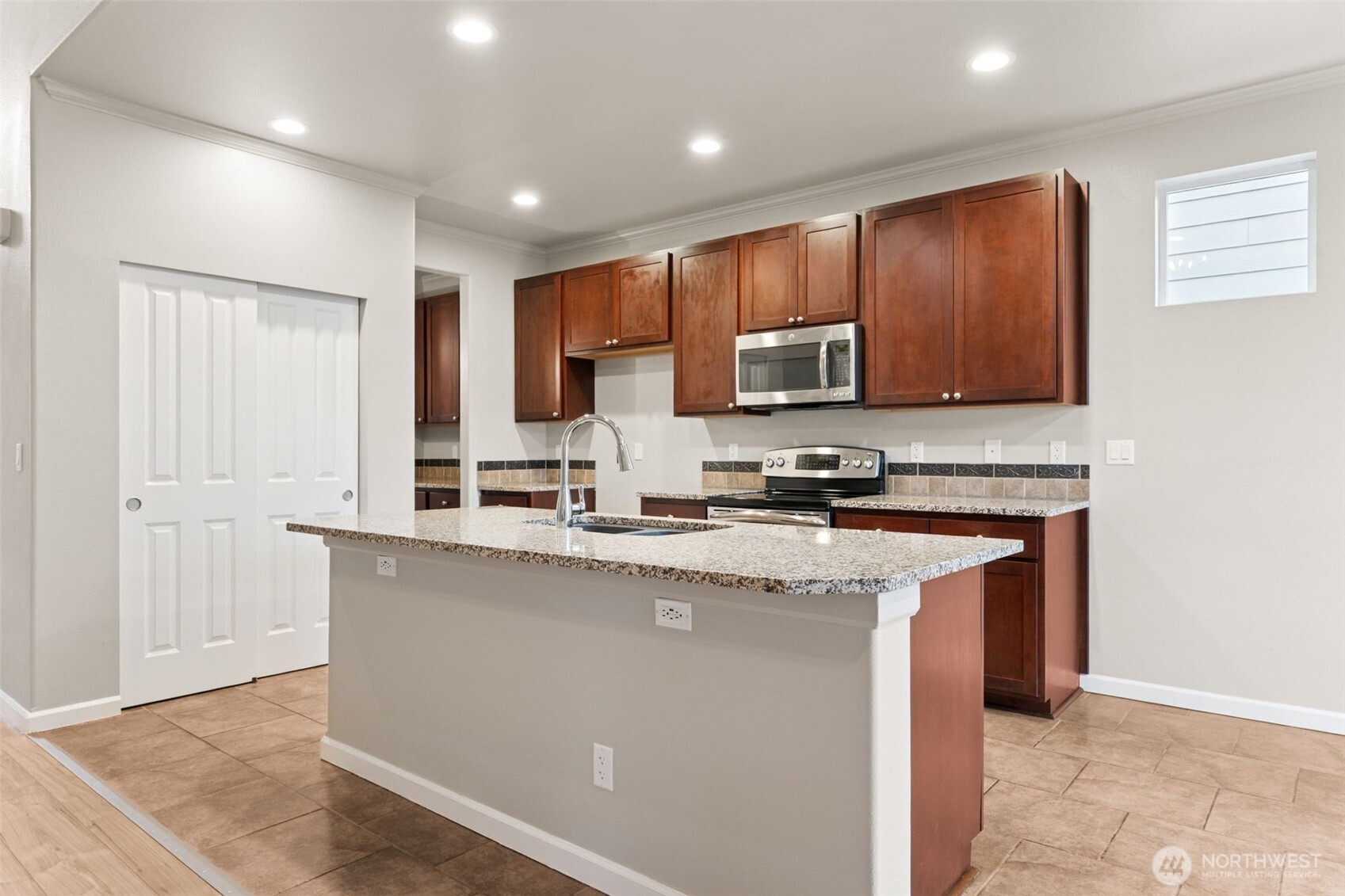 9248 Periwinkle Loop Northeast Olympia, WA 98516 - Photo 7 of 39 a kitchen with stainless steel appliances granite countertop a stove a sink and a microwave