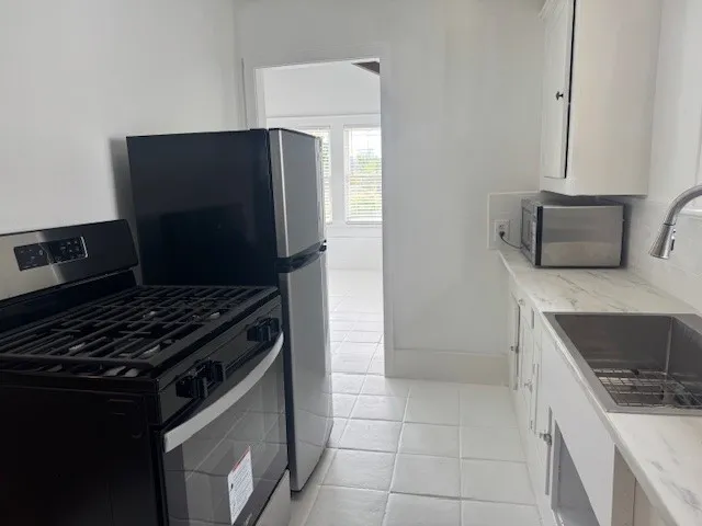 a kitchen with stainless steel appliances a sink stove and cabinets