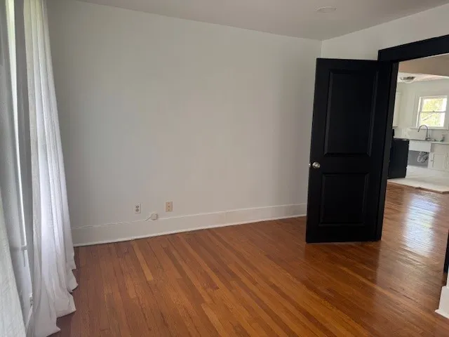 an empty room with wooden floor and a window
