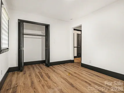 a view of empty room with wooden floor