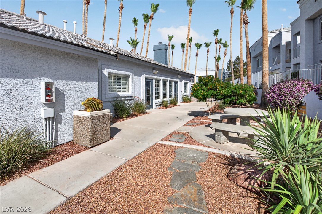 2201 Ramsgate Drive, Unit 1011 Henderson, NV 89074 - Photo 35 of 40 Concrete pathways lead through desert landscaping to a communal outdoor seating area.