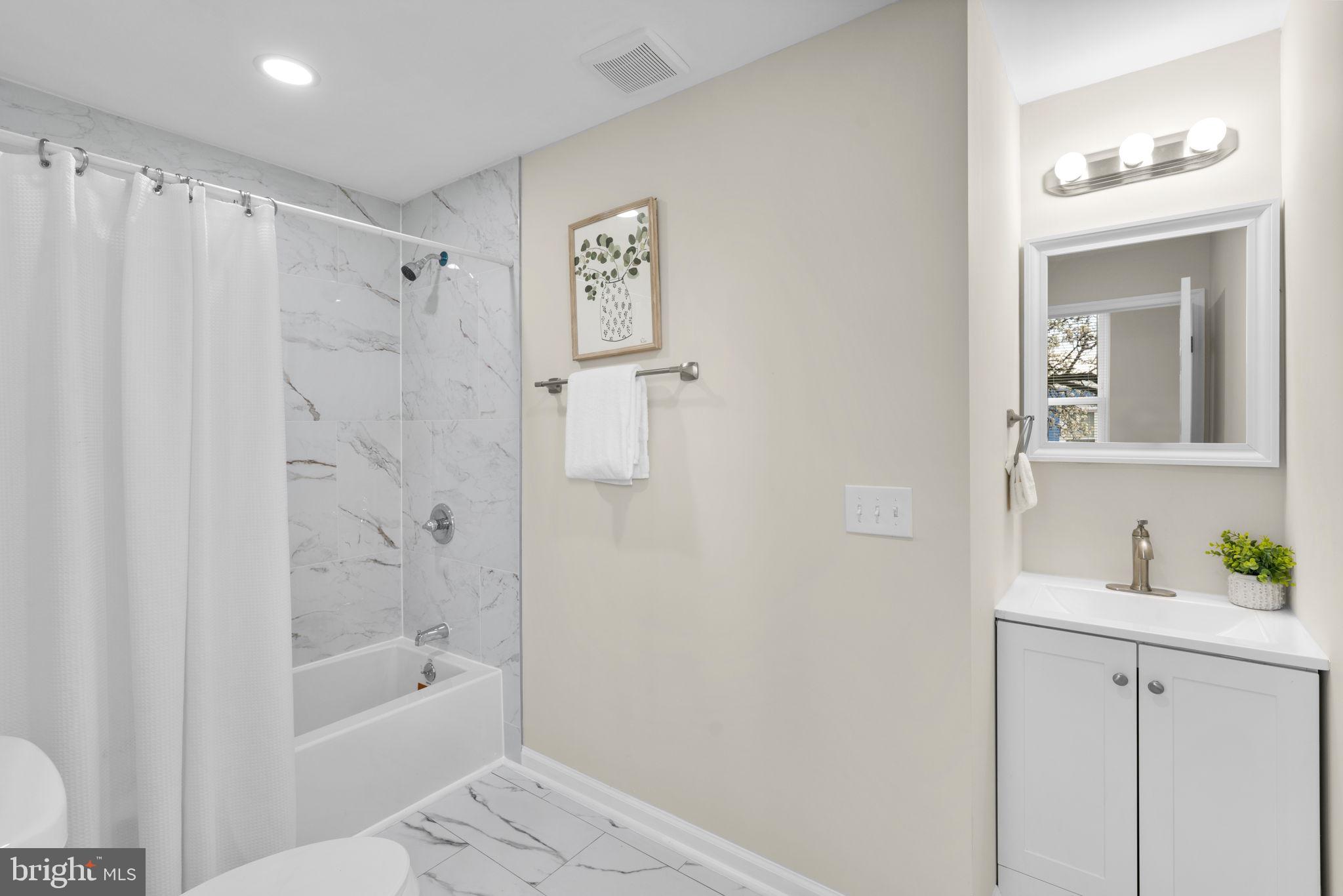 3111 Foster Avenue Baltimore, MD 21224 - Photo 11 of 28 a bathroom with a shower curtain and a sink