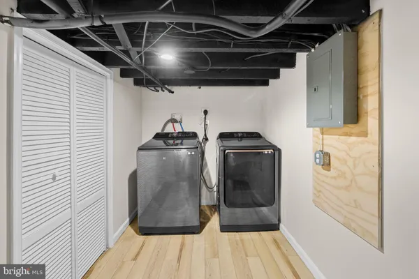 a utility room with wooden floor washer and dryer