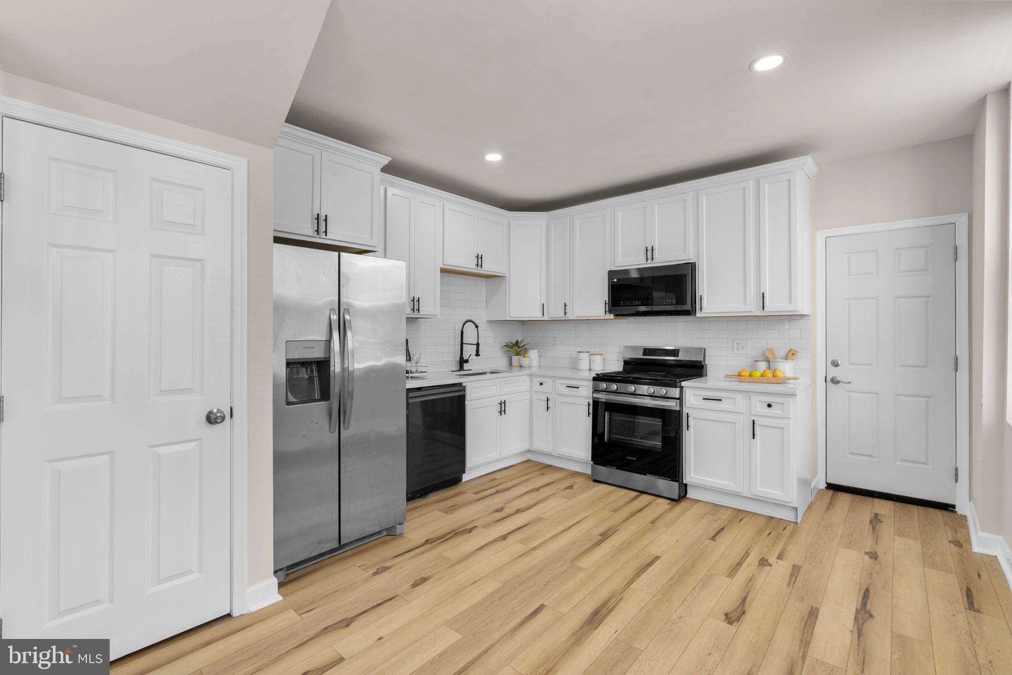 3111 Foster Avenue Baltimore, MD 21224 - Photo 5 of 28 a kitchen with a refrigerator stove and wooden cabinets
