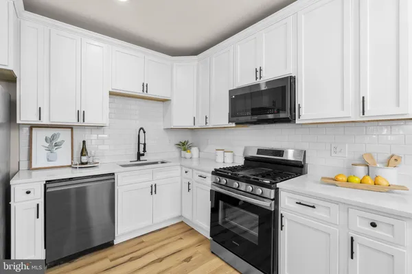 a kitchen with stainless steel appliances granite countertop a sink a stove and a microwave