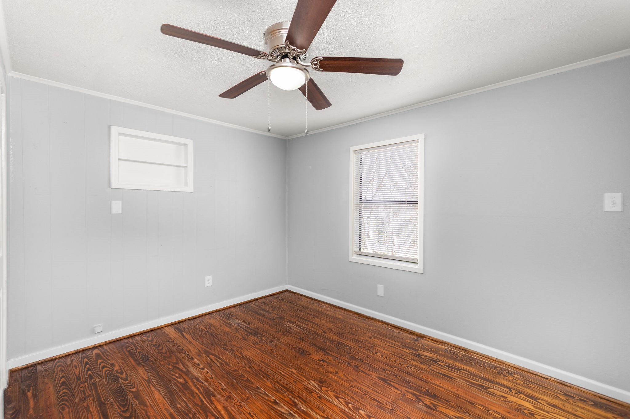 203 South Fig Street Sweeny, TX 77480 - Photo 14 of 20 Master bedroom featuring refinished wood floors and an adjoining bathroom with a full tub.