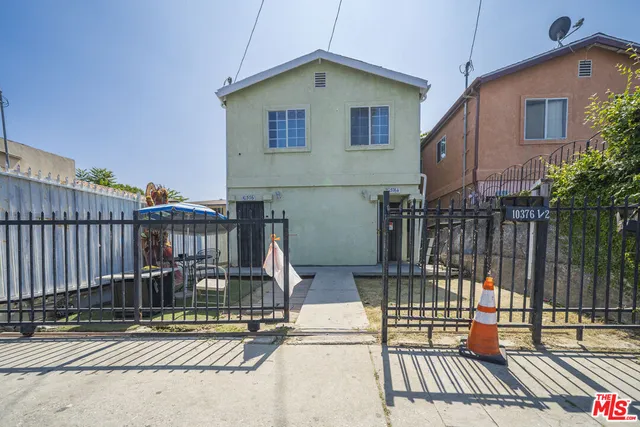a view of a house with wooden fence
