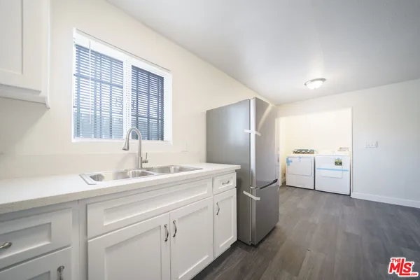 a kitchen with a sink cabinets stainless steel appliances and a window